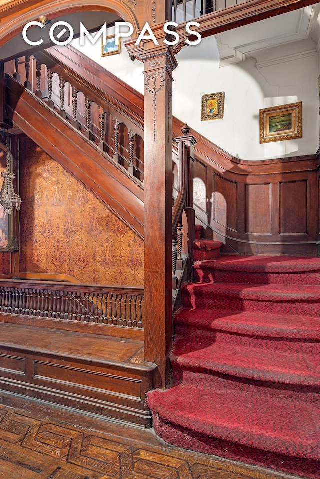 32 W 85th St, New York City, NY 10024 - stairs featuring crown molding, a wainscoted wall, and a decorative wall