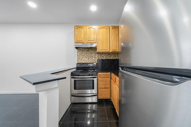 kitchen with a peninsula, under cabinet range hood, dark countertops, and stainless steel appliances