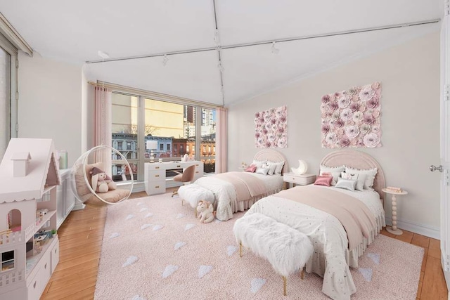 bedroom featuring track lighting and light wood-style flooring