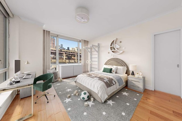 bedroom with crown molding and wood finished floors