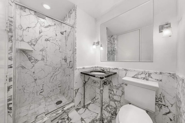full bathroom featuring a marble finish shower, wainscoting, toilet, and tile walls