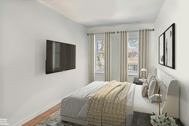 bedroom with baseboards and wood finished floors