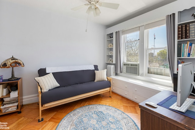 sitting room featuring baseboards, a ceiling fan, radiator heating unit, and cooling unit