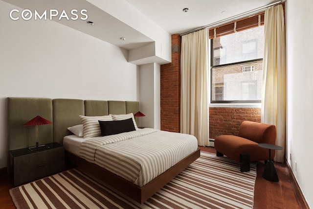 40 W 13th St Unit 2, New York City, NY 10011 - bedroom featuring brick wall, wood finished floors, and baseboards