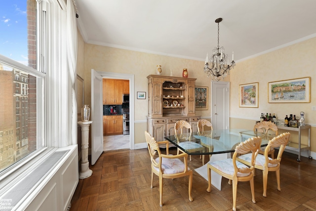 dining space with crown molding, baseboards, and a notable chandelier