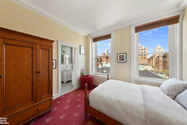 bedroom featuring crown molding, ensuite bath, carpet floors, a view of city, and baseboards