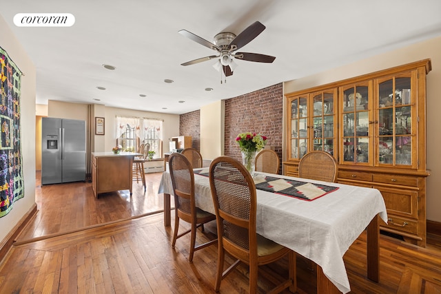 dining space with wood-type flooring, a ceiling fan, and visible vents