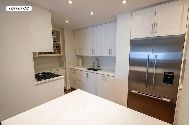 303 E 57th St Unit 16F, New York City, NY 10022 - kitchen with built in fridge, a sink, gas cooktop, white cabinets, and recessed lighting