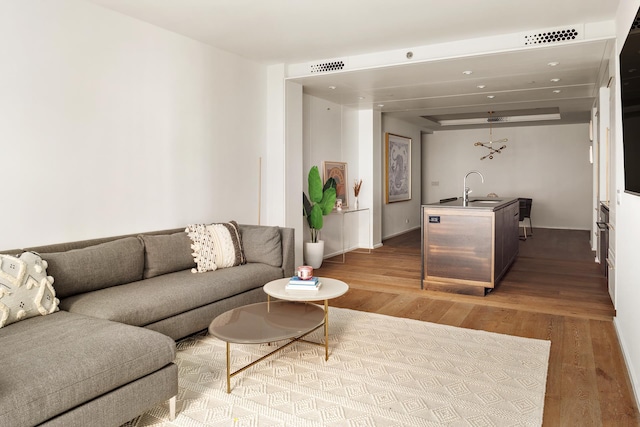 living area with visible vents, baseboards, and wood finished floors