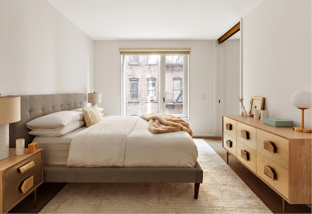 bedroom with wood finished floors and access to exterior