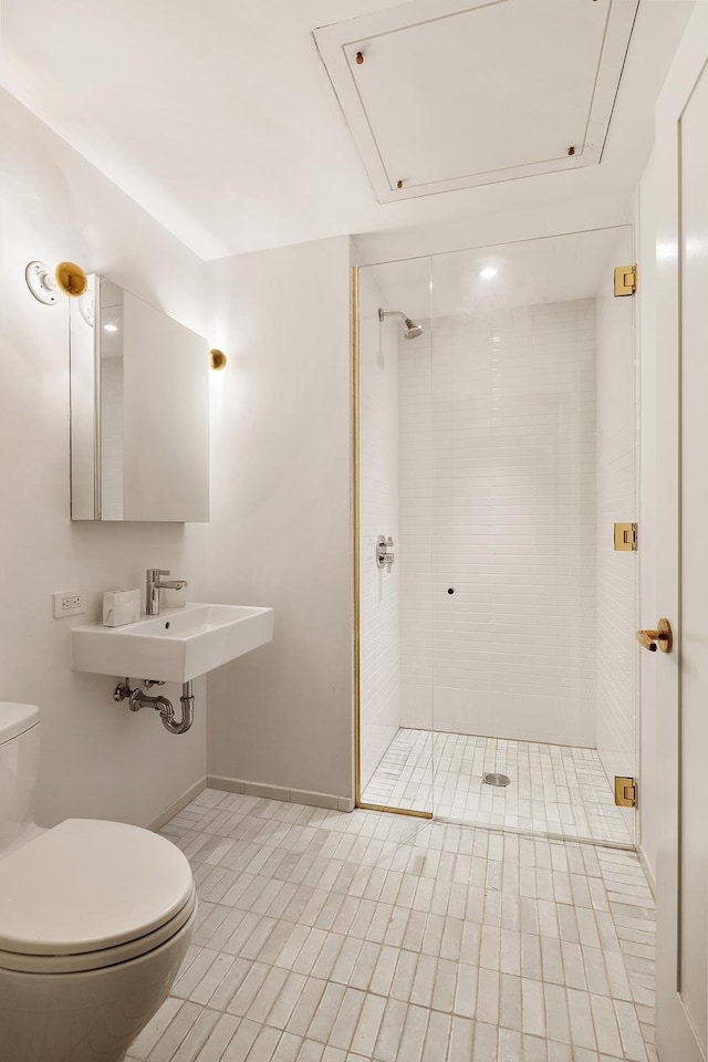 full bath with toilet, baseboards, tile patterned floors, a sink, and a stall shower