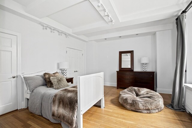 71 Park Ave Unit 3B, New York City, NY 10016 - bedroom featuring rail lighting, wood-type flooring, baseboards, and beam ceiling
