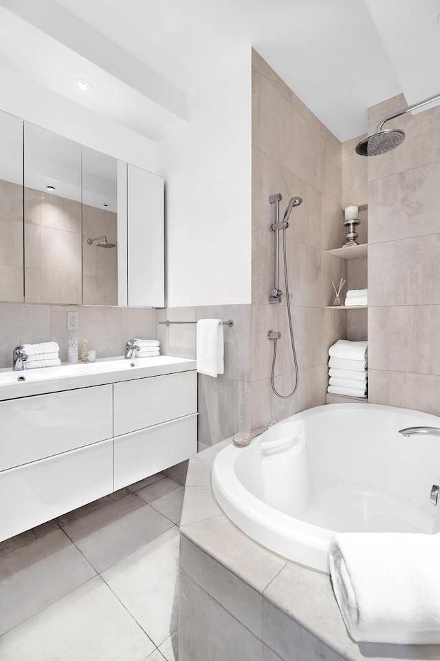 bathroom featuring a relaxing tiled tub, a tile shower, tile patterned flooring, vanity, and tile walls