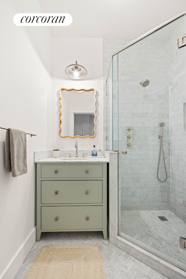 full bath featuring vanity, baseboards, and a stall shower