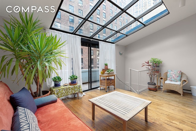 interior space with a skylight, a baseboard heating unit, and a healthy amount of sunlight