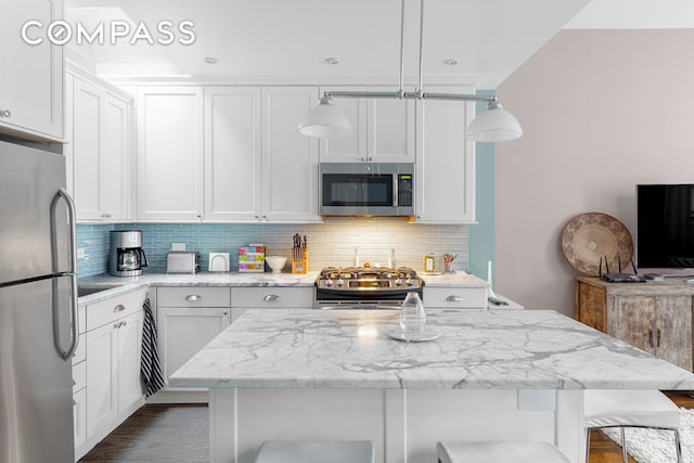 161 W 71st St Unit 4, New York City, NY 10023 - kitchen with stainless steel appliances, a kitchen bar, backsplash, and light stone countertops