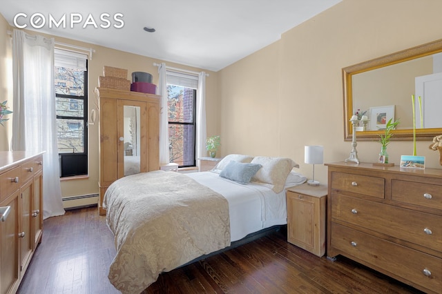 bedroom featuring a baseboard radiator, dark wood-style floors, and multiple windows