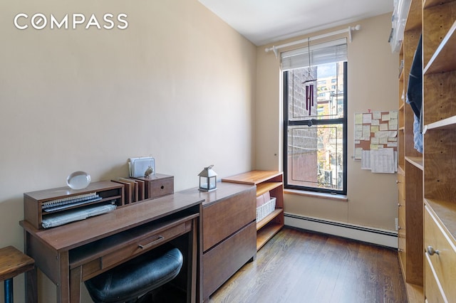 home office featuring a baseboard heating unit and wood finished floors