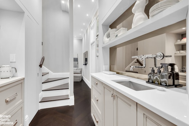 interior space featuring parquet flooring, stairs, a sink, baseboards, and recessed lighting