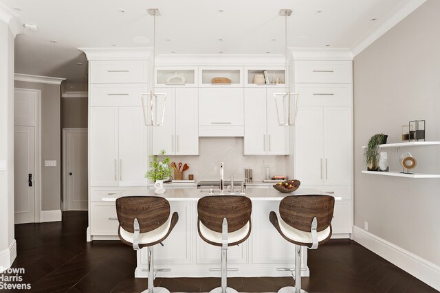 140 W 69th St Unit 812, New York City, NY 10023 - kitchen with light countertops, a sink, crown molding, baseboards, and white cabinets