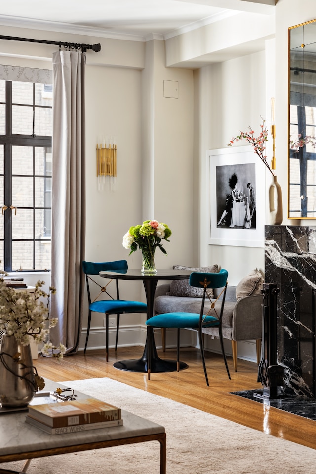 sitting room featuring plenty of natural light, ornamental molding, and wood finished floors