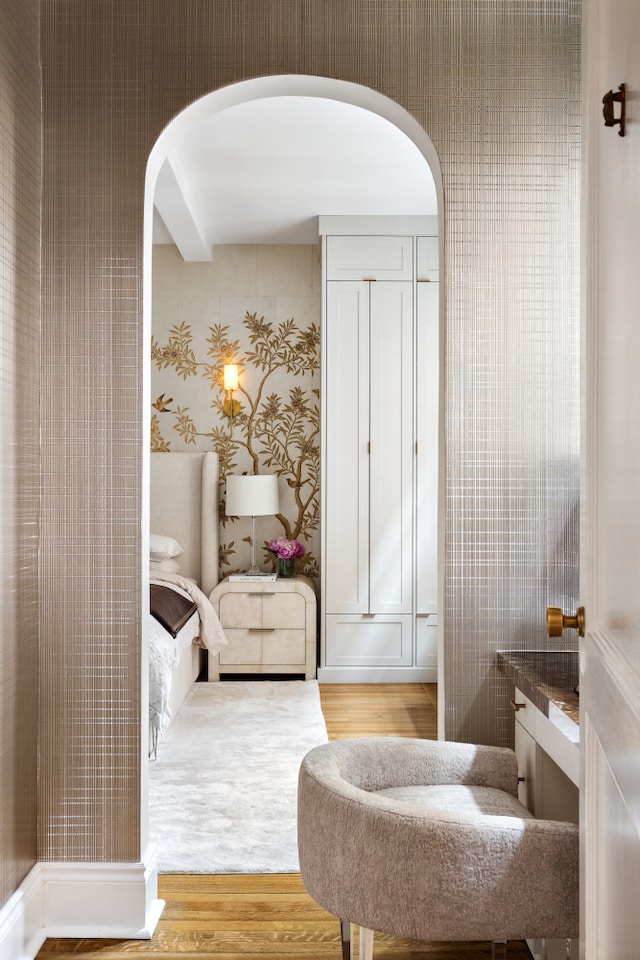 bathroom with wood finished floors and wallpapered walls