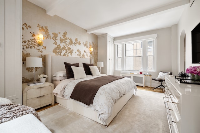 bedroom featuring beam ceiling, radiator heating unit, wallpapered walls, light wood-type flooring, and arched walkways
