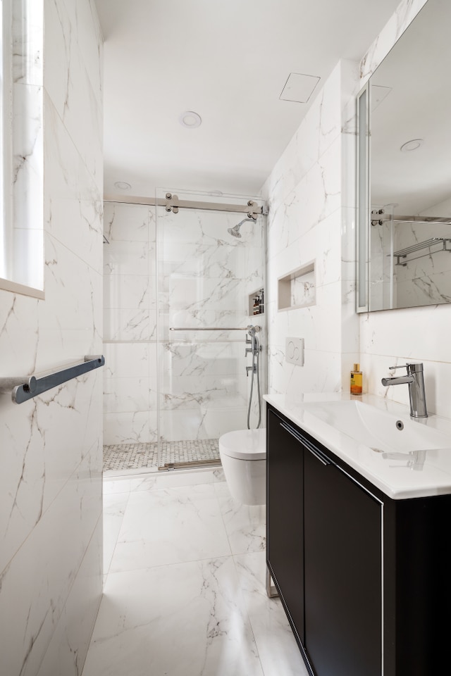 bathroom featuring toilet, a marble finish shower, marble finish floor, and vanity