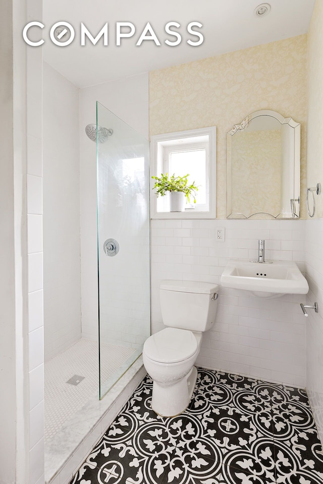 bathroom featuring a sink, walk in shower, tile patterned floors, and toilet