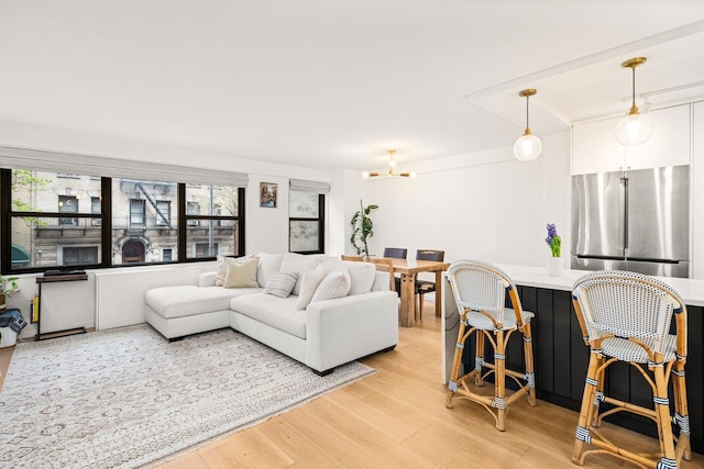 living area featuring a notable chandelier and light wood-type flooring