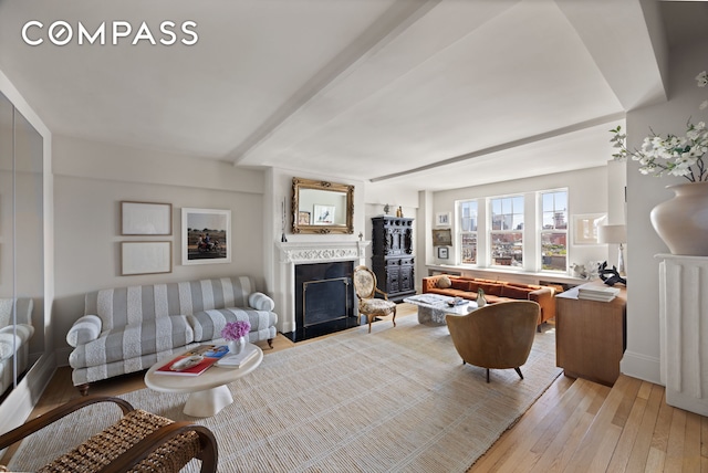 living area with a fireplace with flush hearth and light wood-type flooring