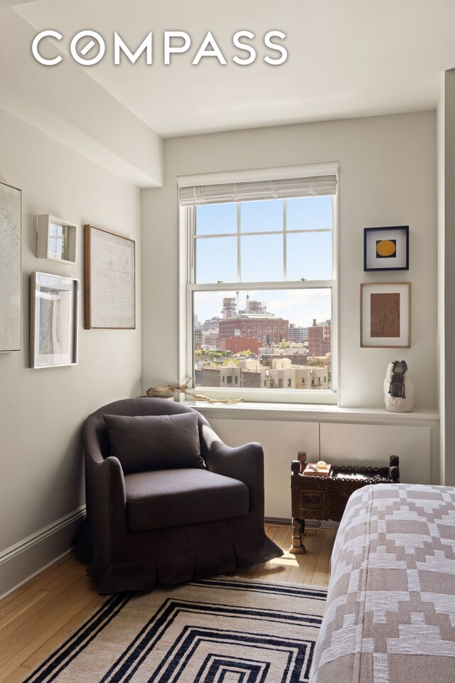 bedroom featuring a view of city and hardwood / wood-style flooring