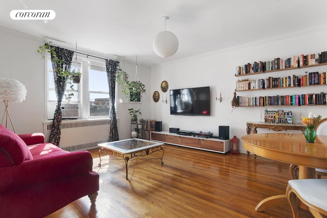 living room featuring crown molding, visible vents, wood finished floors, and radiator