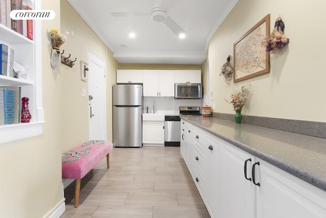kitchen featuring ornamental molding, white cabinetry, ceiling fan, and stainless steel appliances