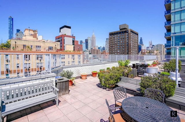 view of patio with outdoor dining area and a city view