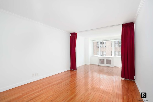 301 E 22nd St Unit 9-G, New York City, NY 10010 - unfurnished room featuring light wood-type flooring, radiator heating unit, ornamental molding, and baseboards