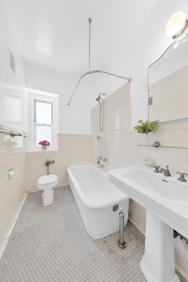 505 W End Ave Unit 2-B, New York City, NY 10024 - bathroom with tile walls, toilet, tile patterned floors, and a wainscoted wall