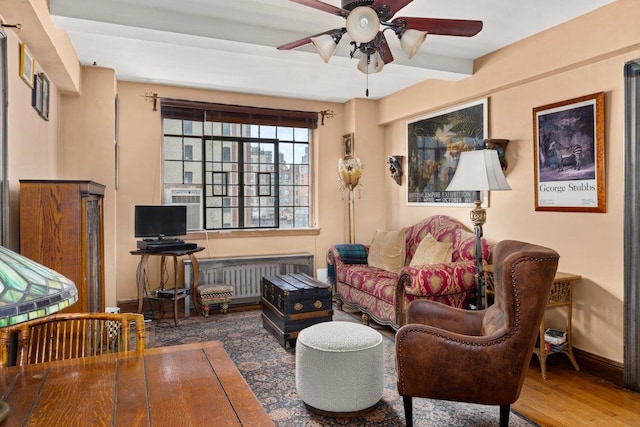 living room with wood finished floors, baseboards, ceiling fan, and radiator heating unit