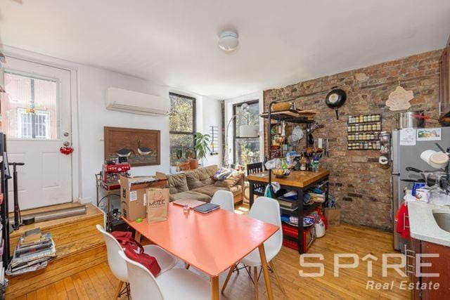 134 Manhattan Ave Bldg, Bldg, New York City, NY 11206 - dining area with a wall unit AC, light wood-type flooring, and healthy amount of natural light