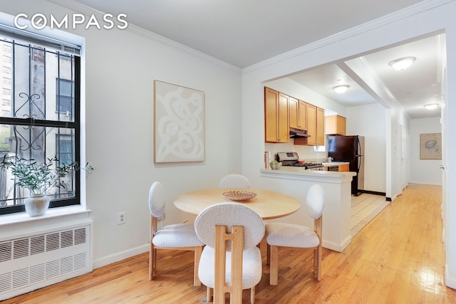 305 W 143rd St Unit 2, New York City, NY 10030 - dining area with radiator heating unit, light wood-style flooring, and crown molding