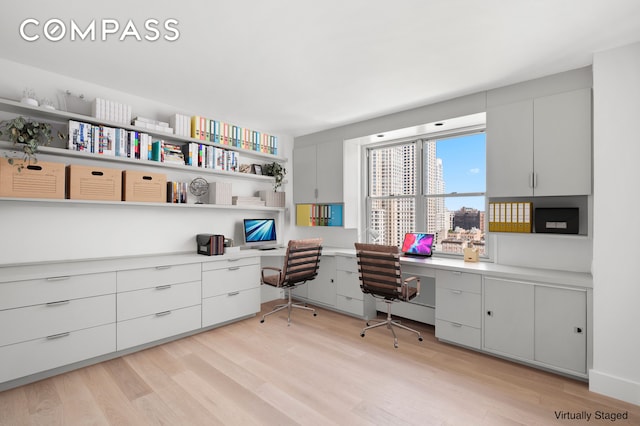 office area featuring light wood finished floors and built in study area