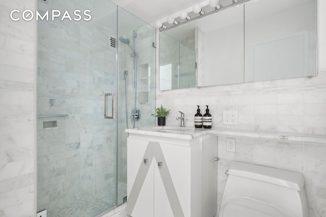full bathroom featuring vanity, a shower stall, and tile walls