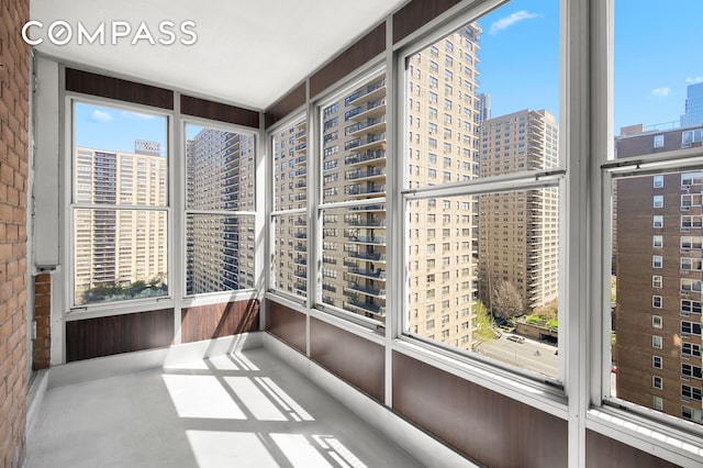 unfurnished sunroom with a city view and a wealth of natural light