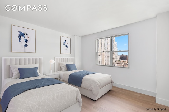 bedroom with baseboards and light wood-style flooring