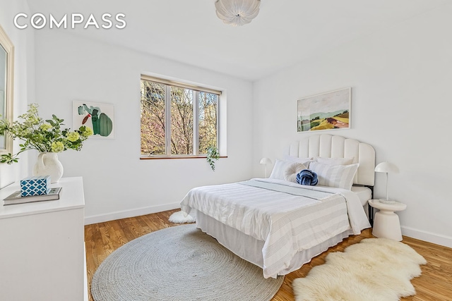 bedroom featuring baseboards and wood finished floors