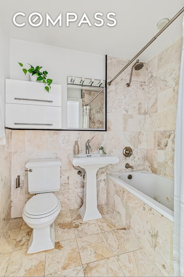 full bathroom featuring a sink, tile walls, tiled shower / bath, and toilet
