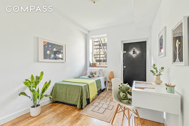 bedroom featuring baseboards and wood finished floors