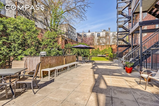 view of home's community with stairs, outdoor dining area, and a patio