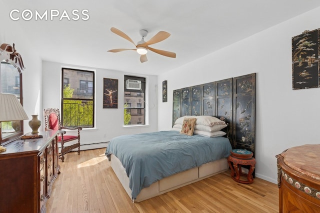 bedroom with light wood-type flooring, baseboard heating, and ceiling fan
