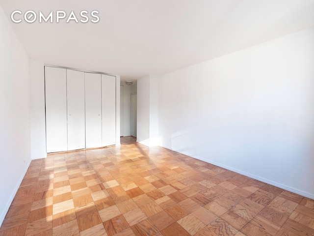unfurnished bedroom with baseboards and a closet